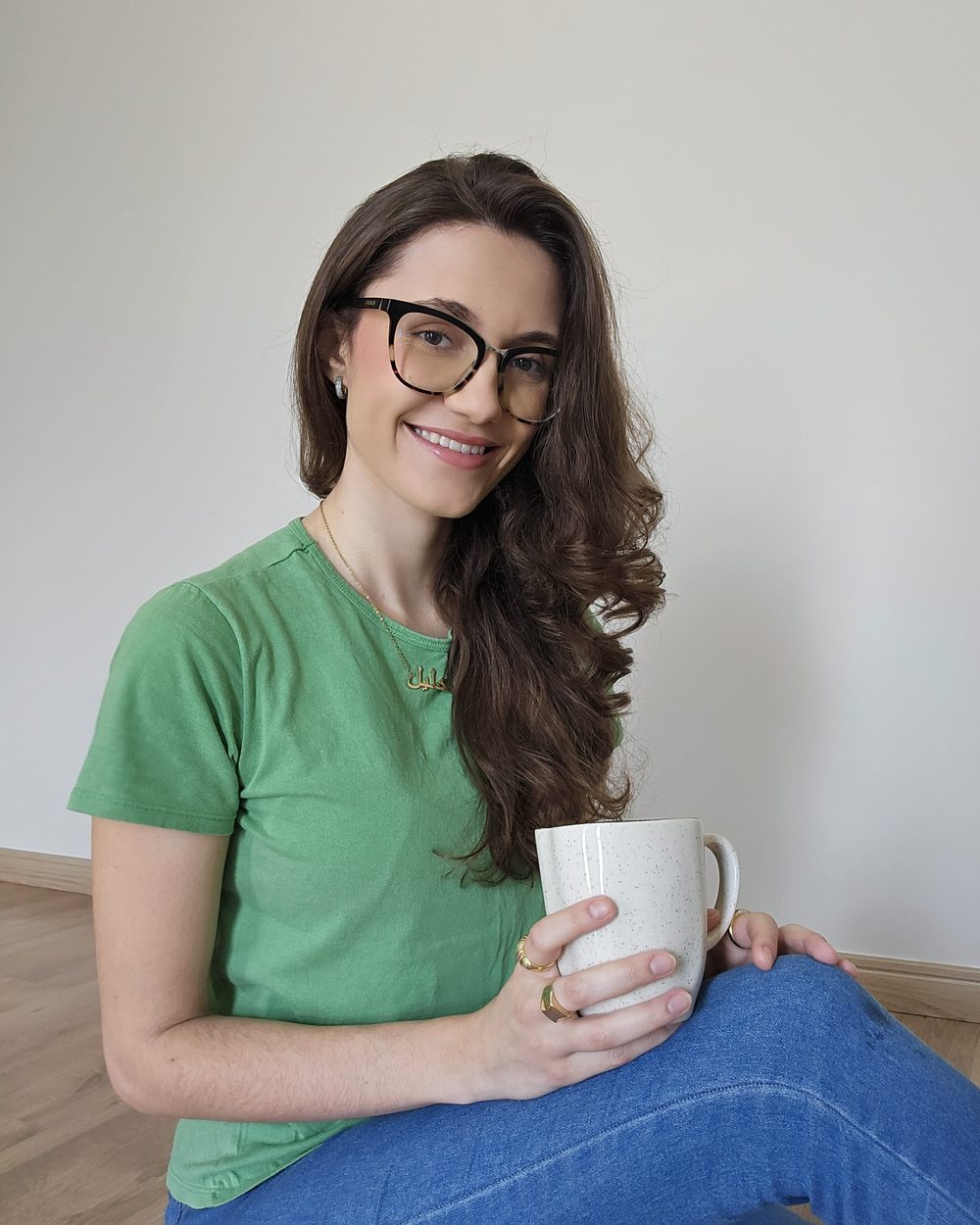 Teacher Ana Kalil sorrindo, segurando uma xícara